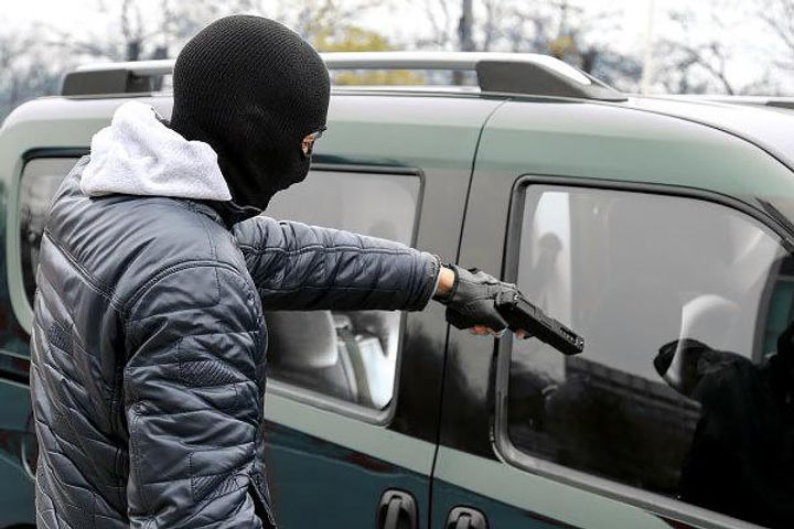 Man's car stolen with wife inside 