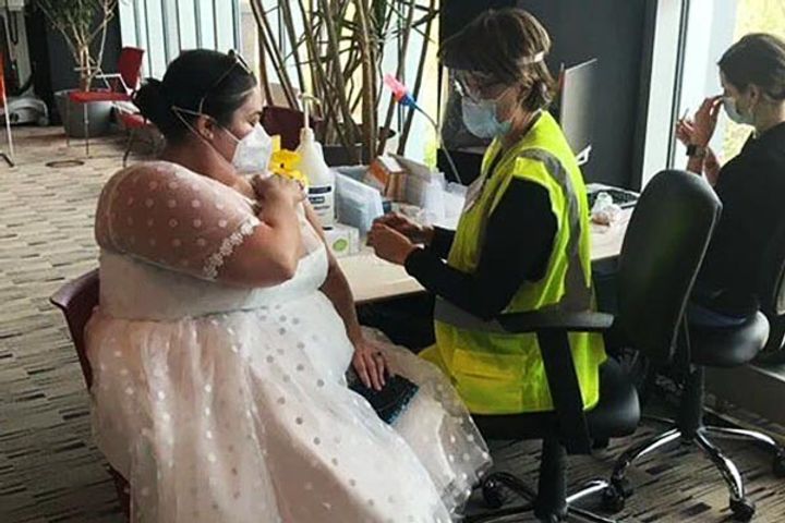Woman wears wedding dress for vaccination